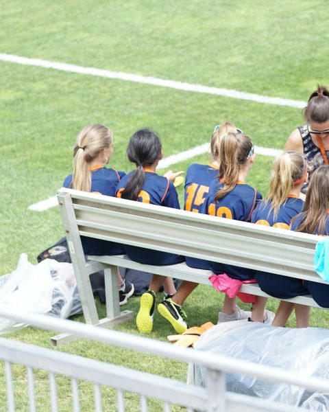eight girls sitting on gray bench