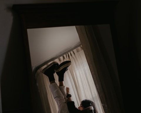 man in black shirt lying on bed