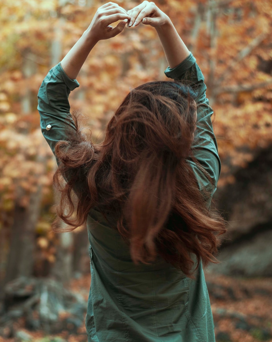 a woman holding her hands up in the air