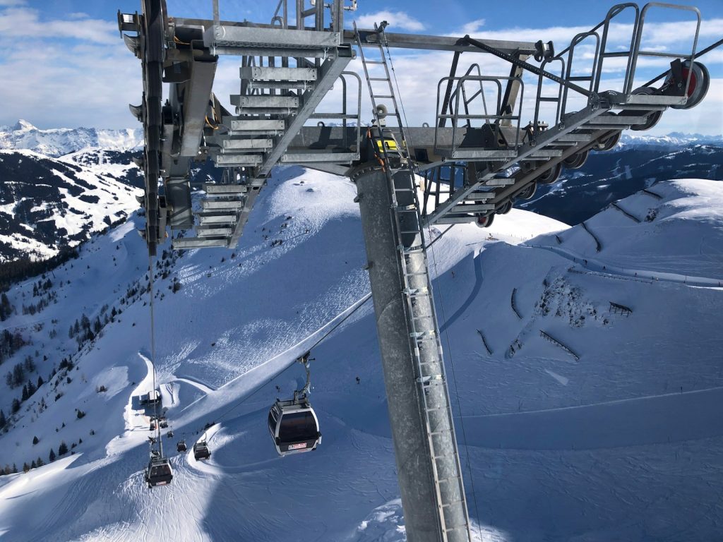 white cable cars overlooking mountain alps