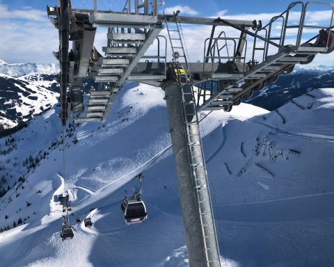 white cable cars overlooking mountain alps