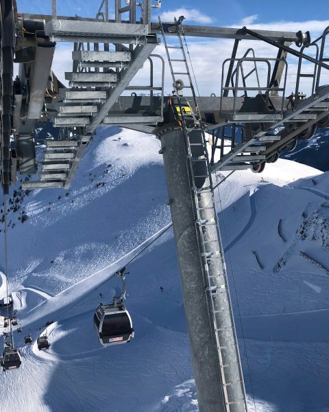 white cable cars overlooking mountain alps