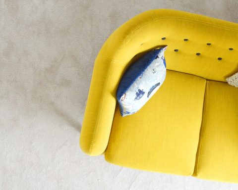 yellow fabric sofa with throw pillow