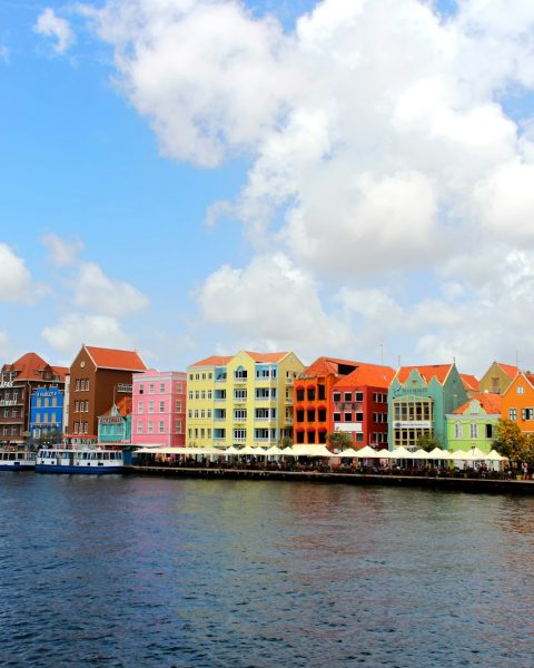 a row of colorful buildings on the side of a body of water
