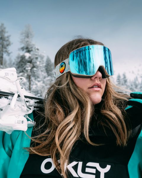 woman in black and white adidas jacket wearing blue sunglasses