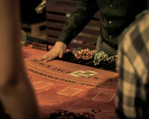 man in green dress shirt sitting on chair
