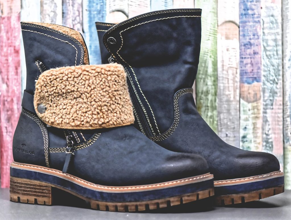Vrouw die een leren schoen aantrekt die te krap zit