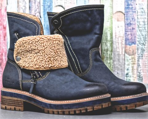 Vrouw die een leren schoen aantrekt die te krap zit