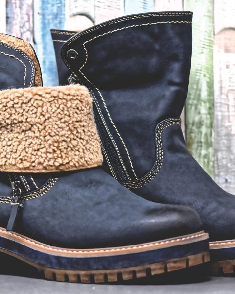Vrouw die een leren schoen aantrekt die te krap zit