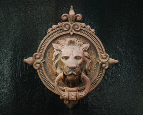 Vrouw raakt een metalen deurklink aan en ervaart een statische schok