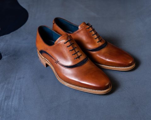 Minimalistische Japanse leren schoenen op een houten ondergrond