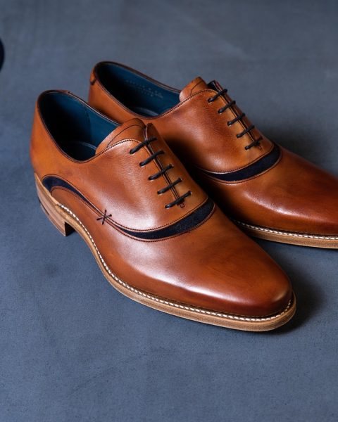 Minimalistische Japanse leren schoenen op een houten ondergrond