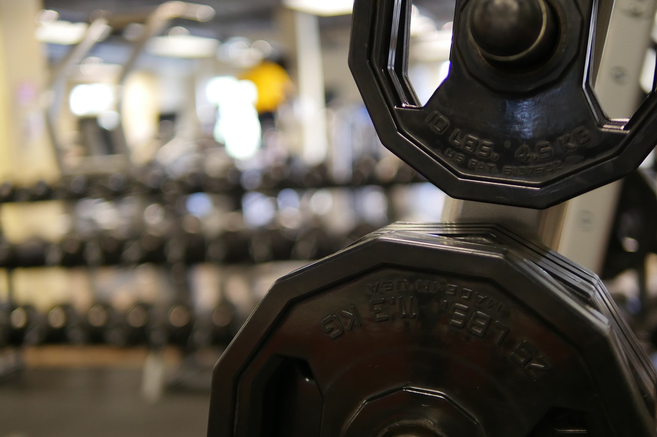 Jonge vrouw die gewichten heft in de sportschool tijdens haar training