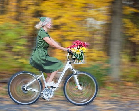 Vrouw test een damesfiets bij een fietsenwinkel
