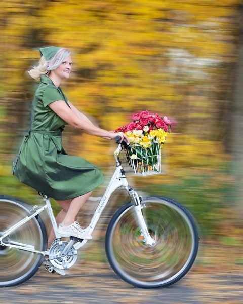 Vrouw test een damesfiets bij een fietsenwinkel