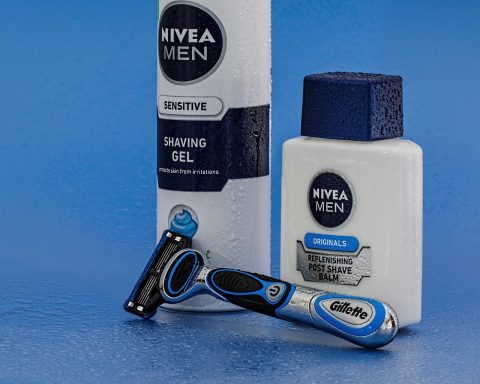 Huidverzorgingsproducten op een badkamerplank, waaronder crèmes en serums