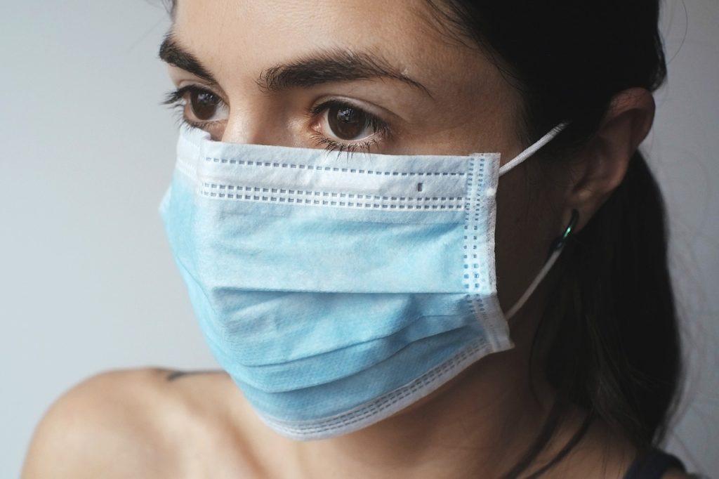 Ayurvedische ingrediënten voor een gezichtsmasker zoals kurkuma, klei en rozenwater op een houten tafel