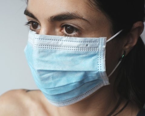 Ayurvedische ingrediënten voor een gezichtsmasker zoals kurkuma, klei en rozenwater op een houten tafel