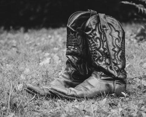Vrouw die leren boots aanpast in een herfstige omgeving