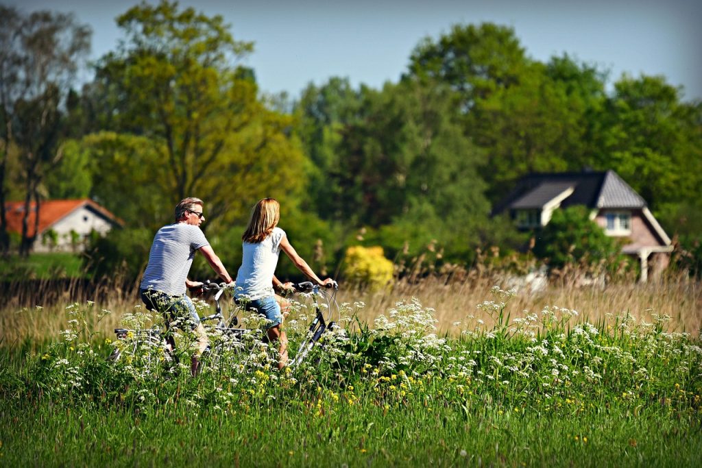 Vriendinnen fietsen samen door een groen Nederlands polderlandschap