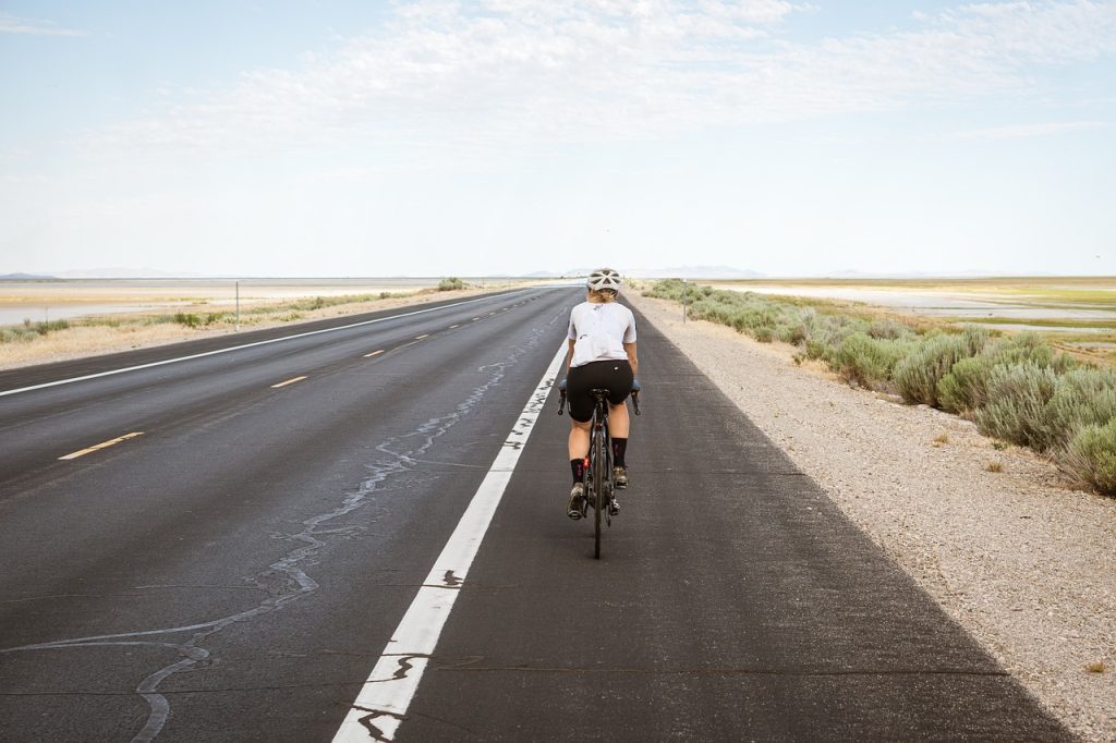 Vrouw op racefiets met klikpedalen op een rustige weg