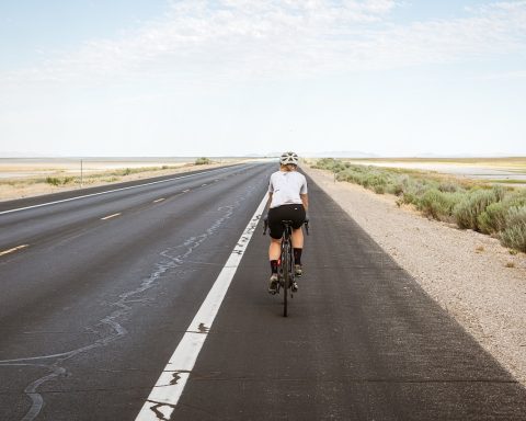 Vrouw op racefiets met klikpedalen op een rustige weg