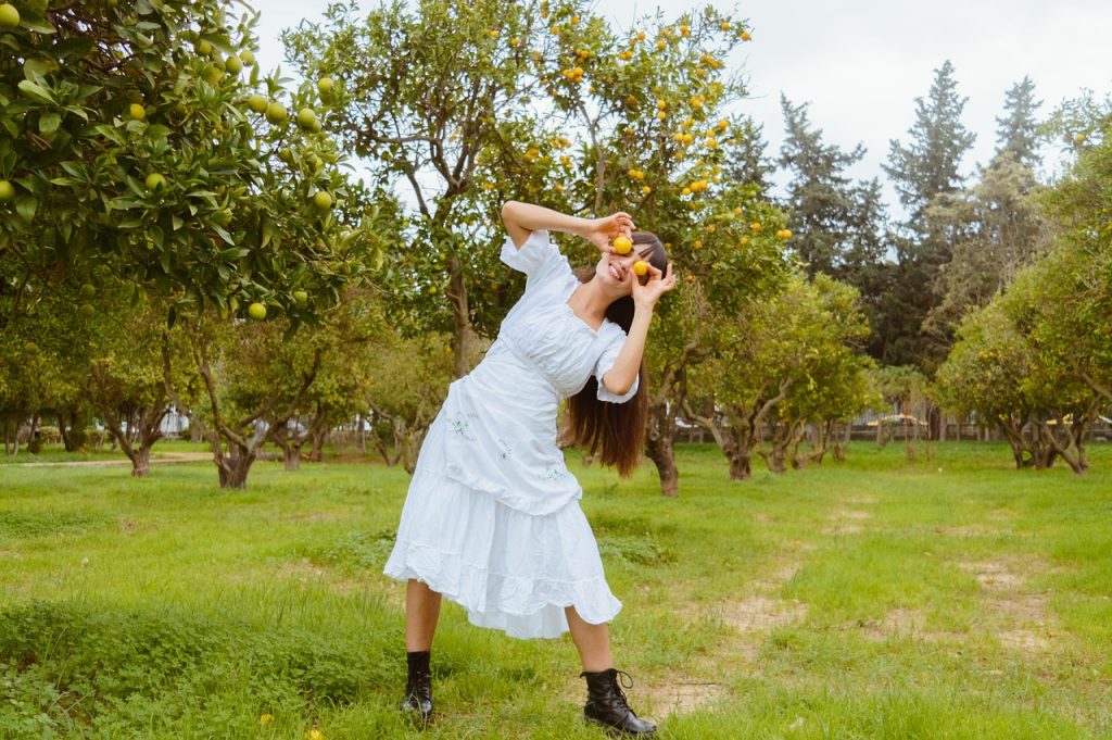 Een vrouw balanceert op een slackline gespannen tussen twee bomen in een bos