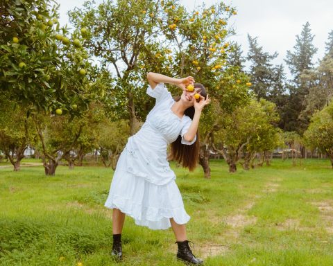 Een vrouw balanceert op een slackline gespannen tussen twee bomen in een bos