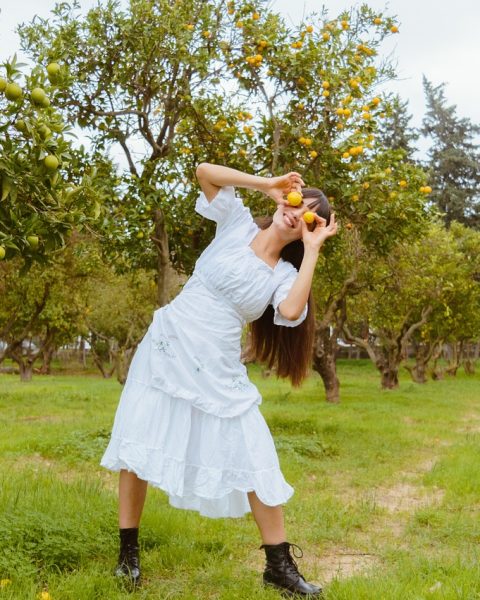 Een vrouw balanceert op een slackline gespannen tussen twee bomen in een bos